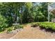 Lush backyard with mature trees, a walkway, fountain, and garden at 210 Wentworth Ter, Alpharetta, GA 30022