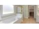 Bathroom features a jacuzzi tub, walk-in shower with gold trim, and a walk-in closet at 210 Wentworth Ter, Alpharetta, GA 30022