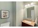 Neutral powder room with granite vanity, picture frame art, and decorative lighting at 210 Wentworth Ter, Alpharetta, GA 30022