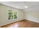 Bedroom with hardwood floors and a large window with outdoor views at 210 Wentworth Ter, Alpharetta, GA 30022