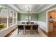 Elegant dining room with olive walls, wainscoting, hardwood floors, large windows, and modern chandelier at 210 Wentworth Ter, Alpharetta, GA 30022