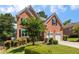 Inviting two-story brick home featuring a two-car garage and beautifully landscaped front yard at 210 Wentworth Ter, Alpharetta, GA 30022