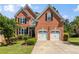 Charming two-story brick home with a well-manicured lawn and a two-car garage at 210 Wentworth Ter, Alpharetta, GA 30022