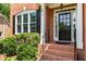 Welcoming front entrance with brick steps, black door, white trim, and manicured bushes at 210 Wentworth Ter, Alpharetta, GA 30022