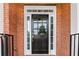 Close-up of a black front door with glass panels, surrounded by white trim and a brick facade at 210 Wentworth Ter, Alpharetta, GA 30022