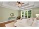 Relaxing main bedroom features a trey ceiling, a ceiling fan, many windows and a view of the backyard at 210 Wentworth Ter, Alpharetta, GA 30022