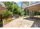 Brick patio with a hot tub, seating under a deck, and a landscaped yard at 210 Wentworth Ter, Alpharetta, GA 30022