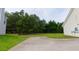 Home backyard featuring a large concrete patio and surrounded by lush greenery at 213 Whistle Way, Locust Grove, GA 30248