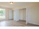 Bright bedroom with laminate flooring and large closet space, illuminated by natural light through a window at 213 Whistle Way, Locust Grove, GA 30248