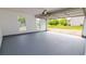 Open garage with painted floor and view to the outdoors through two windows and the garage door at 213 Whistle Way, Locust Grove, GA 30248