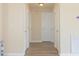 Bright hallway featuring neutral paint, hardwood floors, and white doors at 213 Whistle Way, Locust Grove, GA 30248