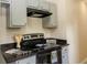 Cozy kitchen featuring granite countertops and stainless steel oven with range hood at 213 Whistle Way, Locust Grove, GA 30248