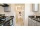Kitchen featuring gray cabinets, granite countertops, and appliances leading to a hallway at 213 Whistle Way, Locust Grove, GA 30248
