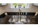 Stainless steel kitchen sink featuring a modern faucet, dark countertops, and a bright window at 213 Whistle Way, Locust Grove, GA 30248