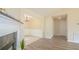 Bright living room featuring a decorative fireplace and hardwood flooring that flows into the dining area at 213 Whistle Way, Locust Grove, GA 30248