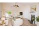 Cozy living room with a fireplace, plush seating, and a modern ceiling fan at 213 Whistle Way, Locust Grove, GA 30248