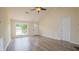Bright living room boasts vaulted ceilings, wood-look floors, and a ceiling fan, creating a spacious and inviting atmosphere at 213 Whistle Way, Locust Grove, GA 30248