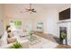 Cozy living room with a fireplace, plush seating, and a modern ceiling fan at 213 Whistle Way, Locust Grove, GA 30248