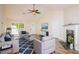 Cozy living room with a fireplace, plush seating, and a modern ceiling fan at 213 Whistle Way, Locust Grove, GA 30248