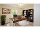 Modern office space featuring a glass-legged desk, built-in shelving, and bright natural light at 213 Whistle Way, Locust Grove, GA 30248