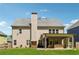 Rear view of home showing covered patio, upper windows, and lush green lawn at 2358 Well Springs Dr, Buford, GA 30519