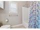 Bright bathroom with a bathtub, colorful shower curtain, and a window at 2358 Well Springs Dr, Buford, GA 30519