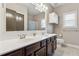 Bathroom with double sink vanity, white countertops, dark wood cabinets, and ample lighting at 2358 Well Springs Dr, Buford, GA 30519