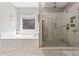 Bathroom featuring soaking tub, separate glass-enclosed shower with marble tile, and natural light at 2358 Well Springs Dr, Buford, GA 30519