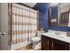 Bathroom with dark blue walls, vanity, and shower with decorative curtain at 2358 Well Springs Dr, Buford, GA 30519