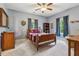 Cozy bedroom with a wooden bed, soft carpet, ceiling fan, and natural light from the windows at 2358 Well Springs Dr, Buford, GA 30519