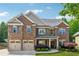 Beautiful two-story brick home featuring a two-car garage, manicured lawn, and inviting front porch at 2358 Well Springs Dr, Buford, GA 30519