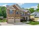 Charming two-story brick home featuring a three-car garage, landscaped yard, and inviting curb appeal at 2358 Well Springs Dr, Buford, GA 30519