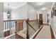 Bright hallway featuring hardwood floors, neutral walls, and a decorative wrought iron railing at 2358 Well Springs Dr, Buford, GA 30519