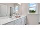 Bright bathroom featuring double sinks with white quartz countertops, a large mirror, and a view of the outdoors at 3198 Shirecrest Ln, Dacula, GA 30019
