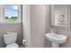 Bathroom with pedestal sink, framed mirror, toilet, and window at 3198 Shirecrest Ln, Dacula, GA 30019