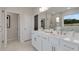 Bright bathroom featuring double sinks, white cabinets, quartz countertops, and a glass enclosed shower at 3198 Shirecrest Ln, Dacula, GA 30019