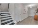 Entryway featuring wood-look flooring, stairs with black treads, and stylish wall art at 3198 Shirecrest Ln, Dacula, GA 30019