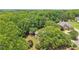 Aerial view of a stately brick home nestled amongst lush trees with a long driveway in a private setting at 3235 Munsey Ct, Cumming, GA 30041