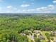 Stunning aerial view of a lush, green neighborhood featuring mature trees and clear skies at 3235 Munsey Ct, Cumming, GA 30041