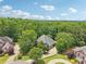 An aerial view of a house nestled among lush green trees in a quiet neighborhood at 3235 Munsey Ct, Cumming, GA 30041