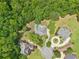 An aerial perspective shows luxury homes with private pools nestled among mature greenery, showcasing exclusive living at 3235 Munsey Ct, Cumming, GA 30041