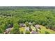 An aerial view displays several community homes nestled amongst mature trees at 3235 Munsey Ct, Cumming, GA 30041