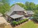 Back of the house featuring beautiful landscaping, patio, and lush green lawn at 3235 Munsey Ct, Cumming, GA 30041
