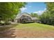 The backyard features a large lawn, mature trees, and a screened-in porch perfect for relaxing and entertaining at 3235 Munsey Ct, Cumming, GA 30041