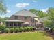 Expansive backyard features a lush lawn, manicured shrubs, a patio, a hot tub, and beautiful landscaping at 3235 Munsey Ct, Cumming, GA 30041