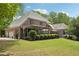 Expansive backyard with covered porch, dining area, and mature trees at 3235 Munsey Ct, Cumming, GA 30041
