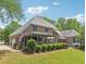 The backyard features a covered patio, lush landscaping, and expansive green space for outdoor enjoyment at 3235 Munsey Ct, Cumming, GA 30041