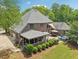 Backyard features a covered patio, lush landscaping, and relaxing outdoor space for gathering and entertaining at 3235 Munsey Ct, Cumming, GA 30041