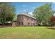 Scenic view of the back exterior of this home highlighting the well-kept lawn and brick facade at 3235 Munsey Ct, Cumming, GA 30041