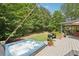 Backyard deck featuring a relaxing hot tub, seating, and lush landscaping at 3235 Munsey Ct, Cumming, GA 30041